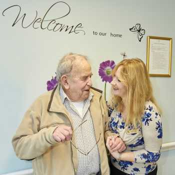 Care home manager smiling and welcoming resident