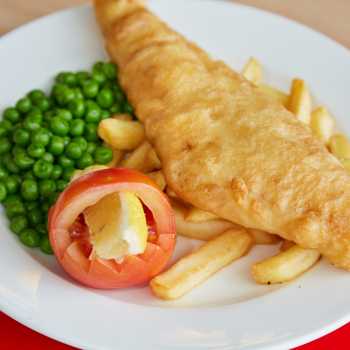 Battered fish, chips and peas on a plate